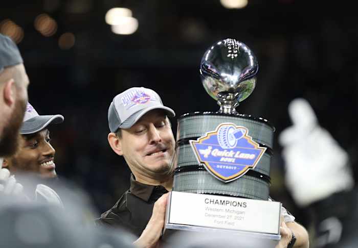 Western Michigan celebrating a Quick Lane Bowl victory with the trophy.